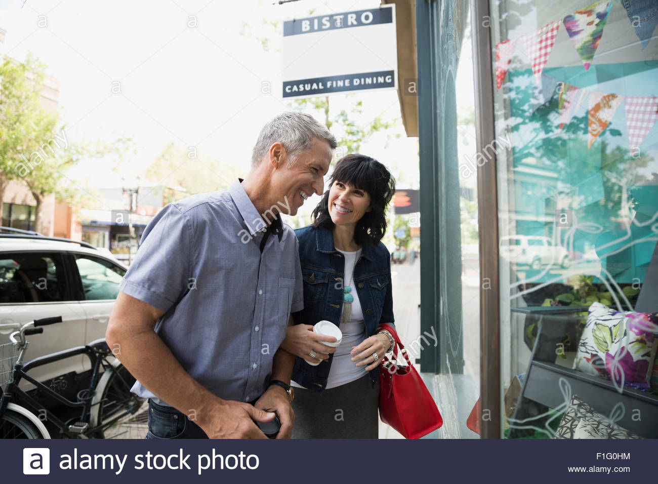 Smiling couple window shopping at storefront Stock Photo