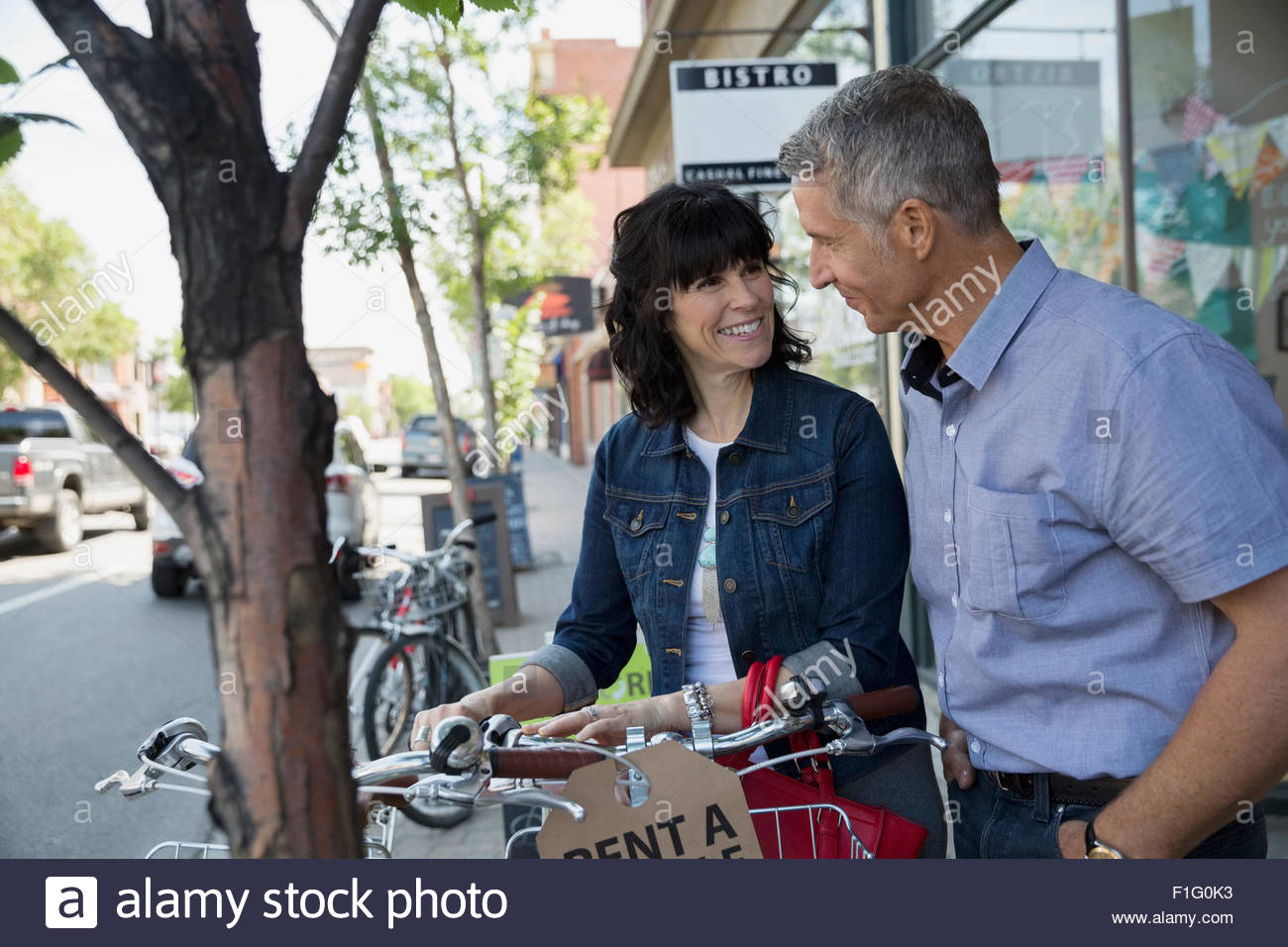 Smiling couple renting bicycle Stock Photo