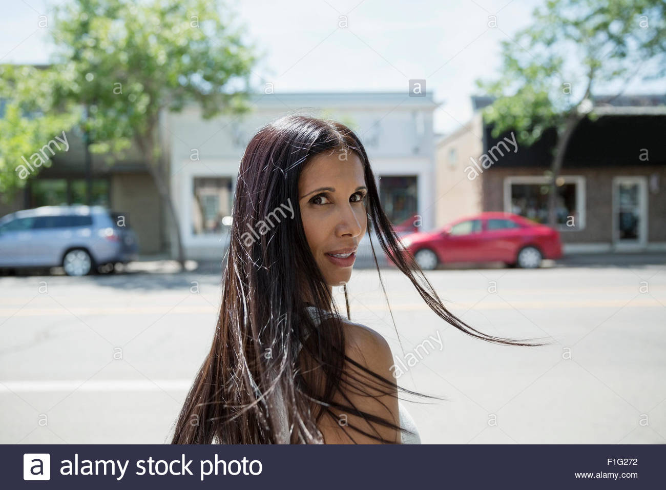 Portrait brunette woman looking over shoulder on street Stock Photo