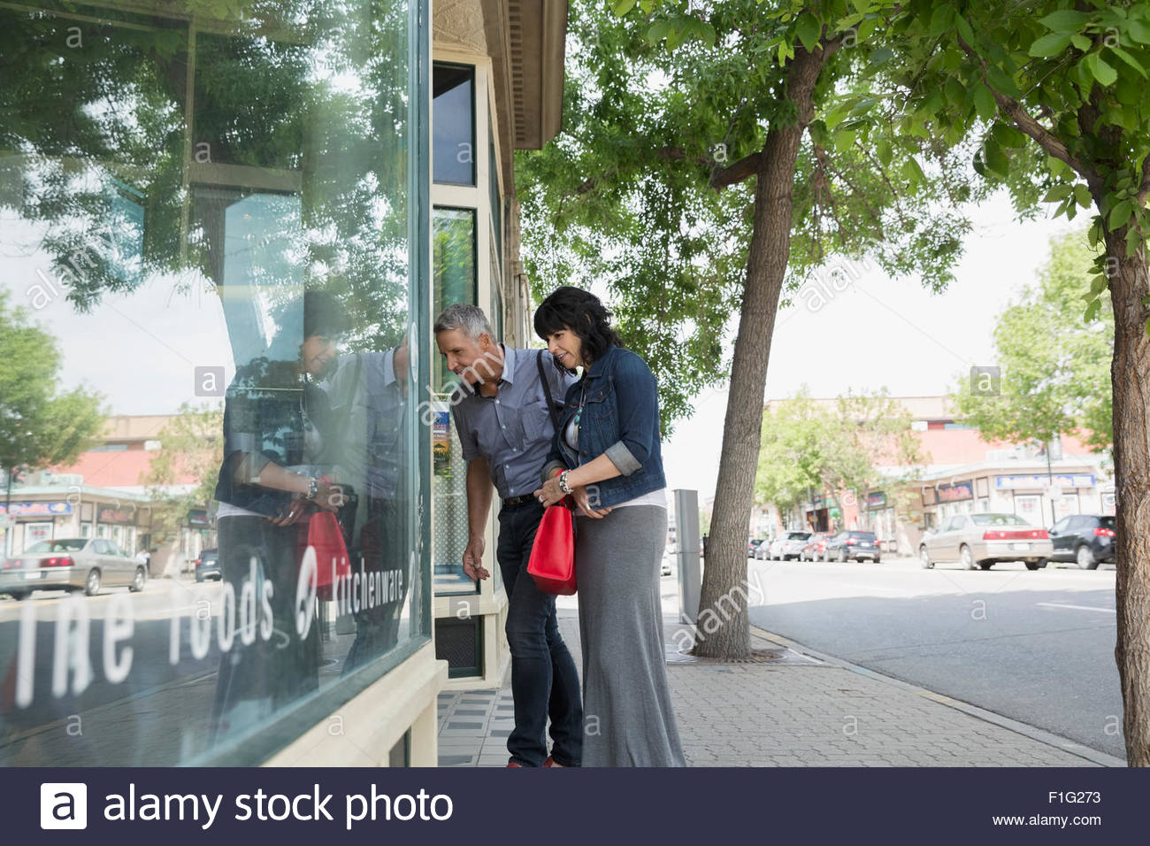 Couple window shopping at storefront Stock Photo