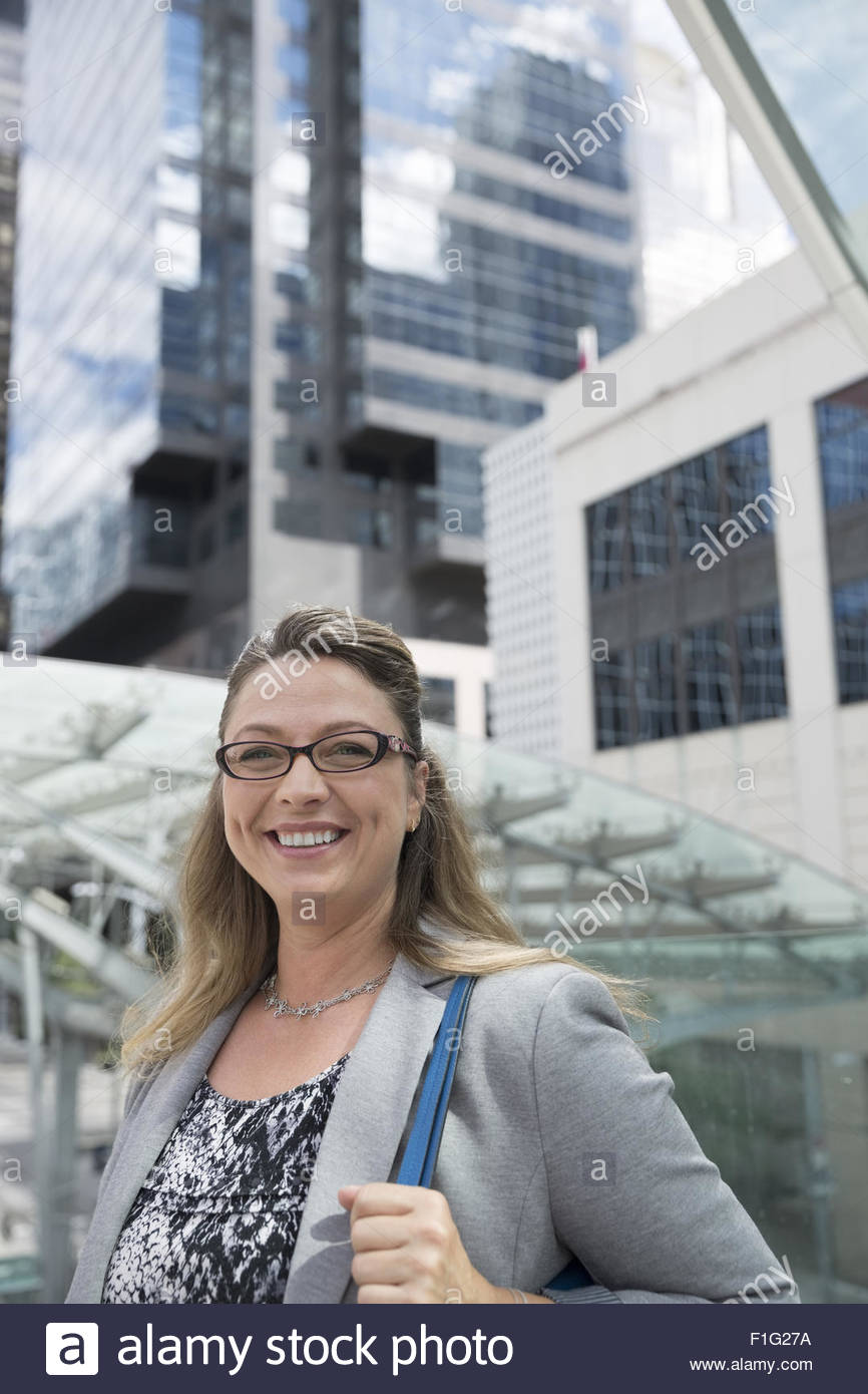 Portrait smiling businesswoman below city highrises Stock Photo