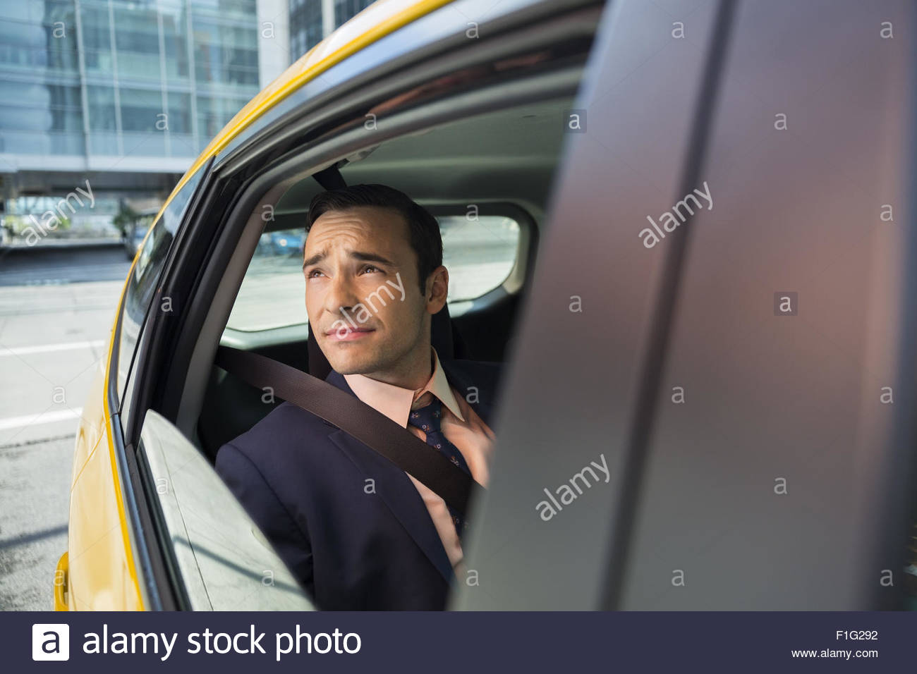 Businessman looking out window of taxi Stock Photo