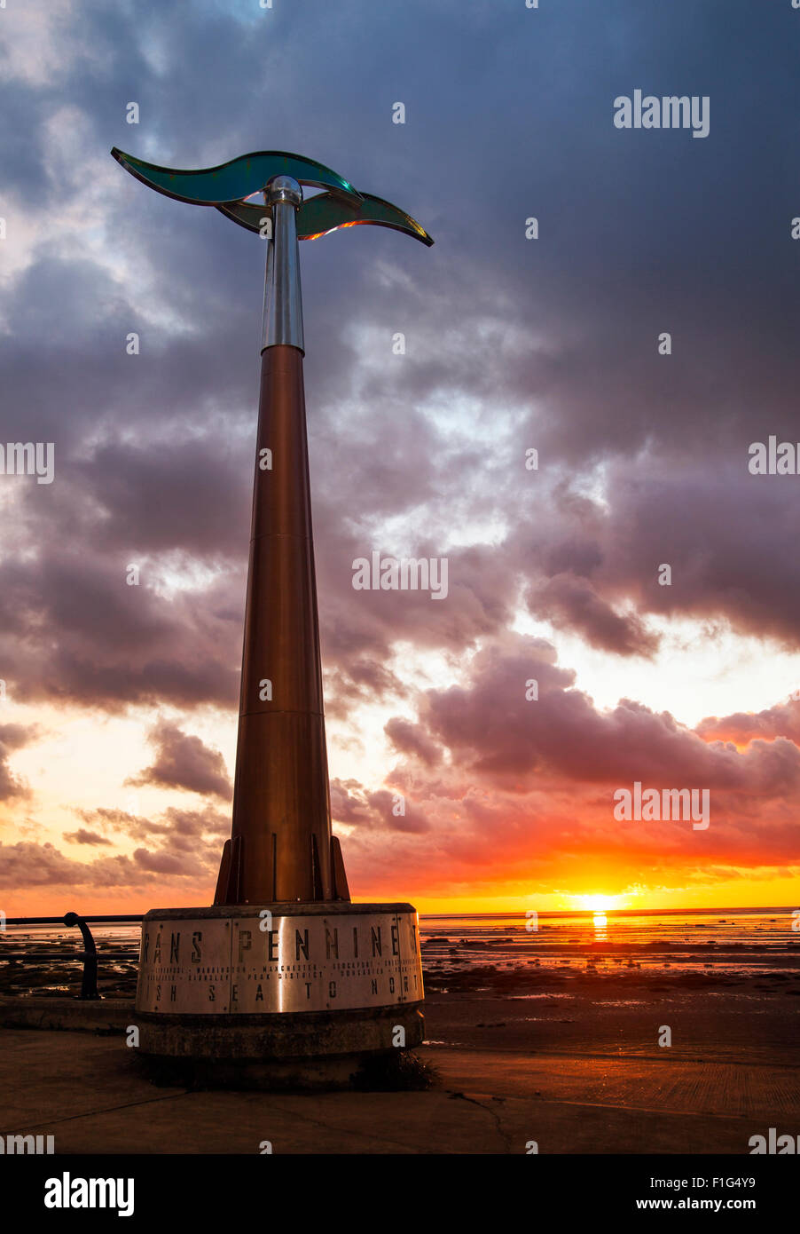Rotating tall spinning weathervane Southport, Seafront & Promenade attractions. Colourful sunset over the Irish Sea on the north west coast of Sefton.  UK Weather wind vane, wind speed and direction instrument;   This device is a TPT Seamark on Southport’s Promenade, a  tall towering outdoor weather station wind spinner, which serves as a marker for the start of the east-west trail of The Trans Pennine coast-to-coast trail. Stock Photo