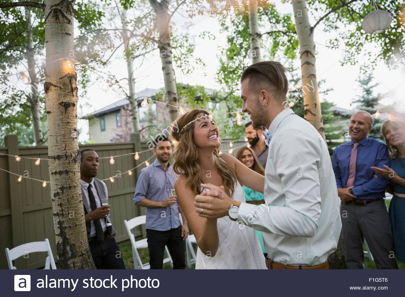 Bride and groom dancing at backyard wedding reception Stock Photo