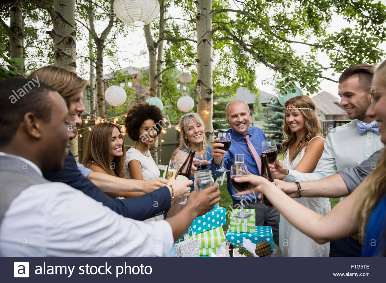 Bride, groom and wedding guests toasting drinks reception Stock Photo