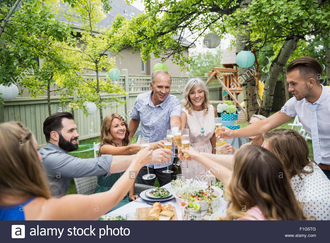 Family toasting champagne flutes at garden party Stock Photo