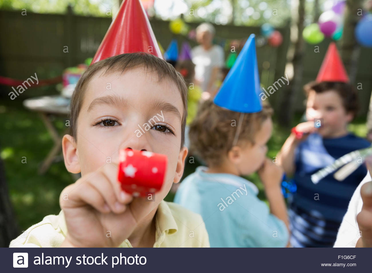 Portrait boy blowing birthday party favor Stock Photo