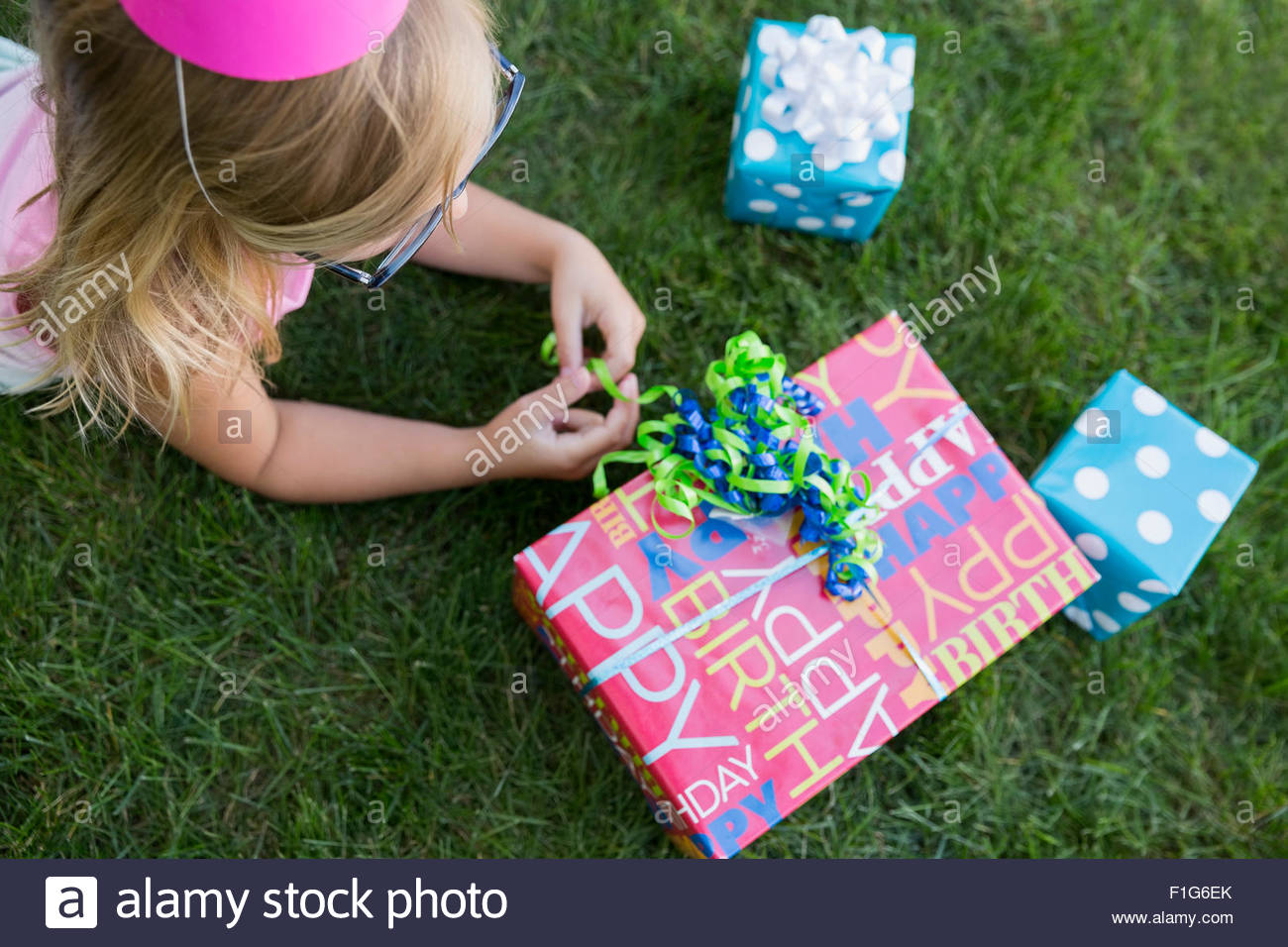 Overhead view girl with birthday gifts in grass Stock Photo