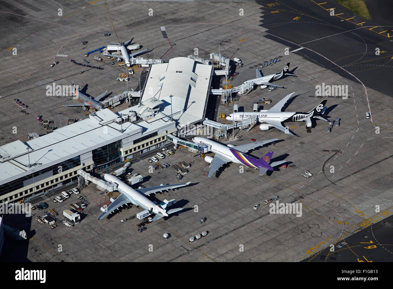 Planes at Auckland Airport International Terminal and Manukau Harbour, North Island, New Zealand - aerial Stock Photo