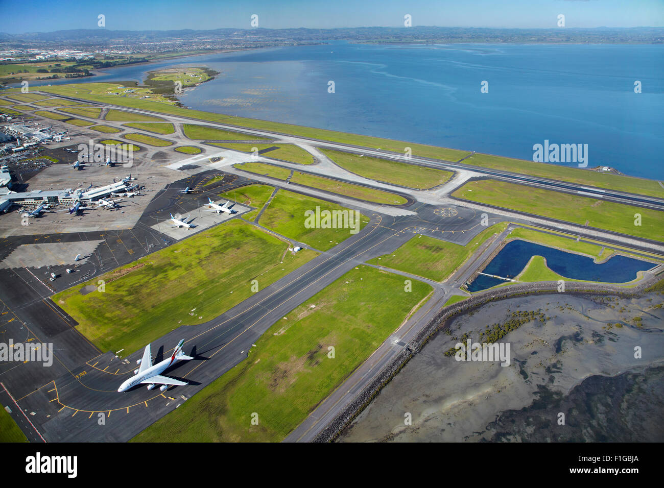 Emirates Airbus A380 and runways at Auckland Airport, North Island, New Zealand - aerial Stock Photo