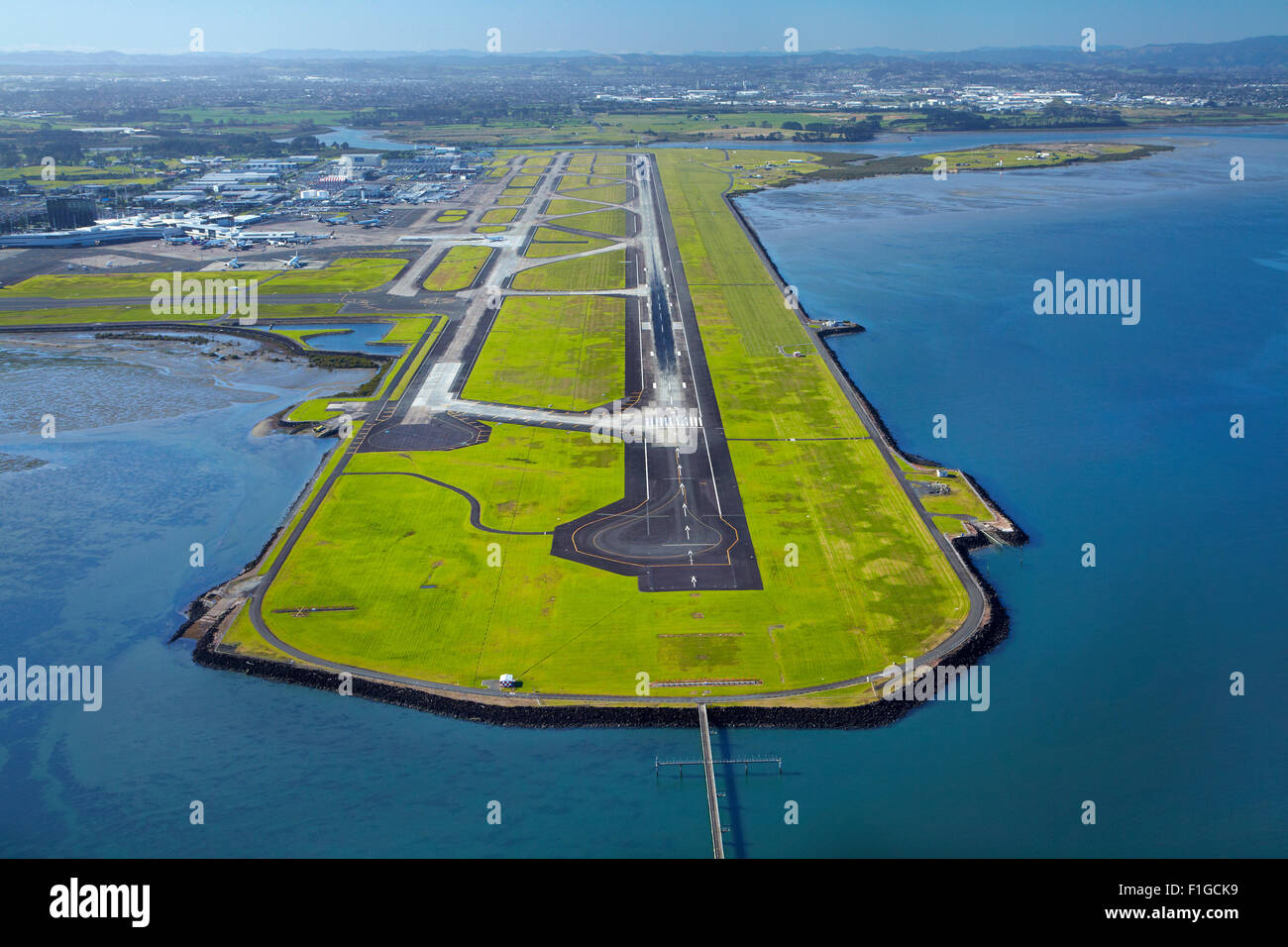 Runway at Auckland Airport, and Manukau Harbour, North Island, New Zealand - aerial Stock Photo
