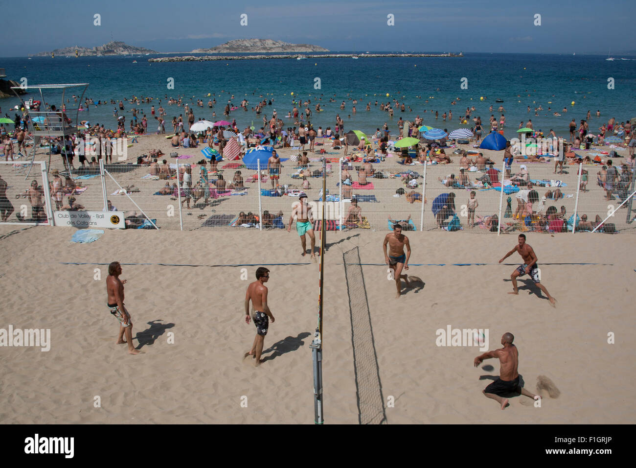People Playing Volleyball On The Busy Catalans Beach Or