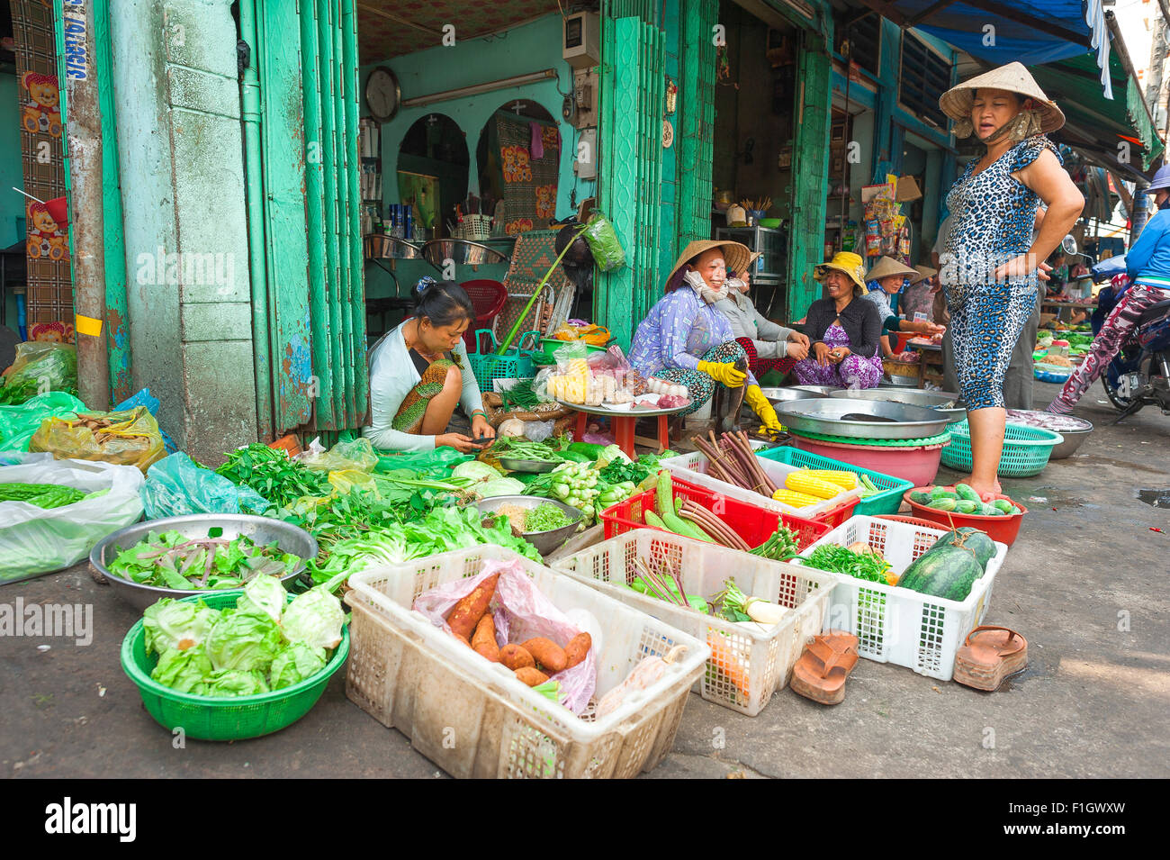 Vietnam market Saigon, on a sidewalk in Binh Tay market in the Cholon area of Saigon Vietnamese women sell fresh vegetables. Stock Photo