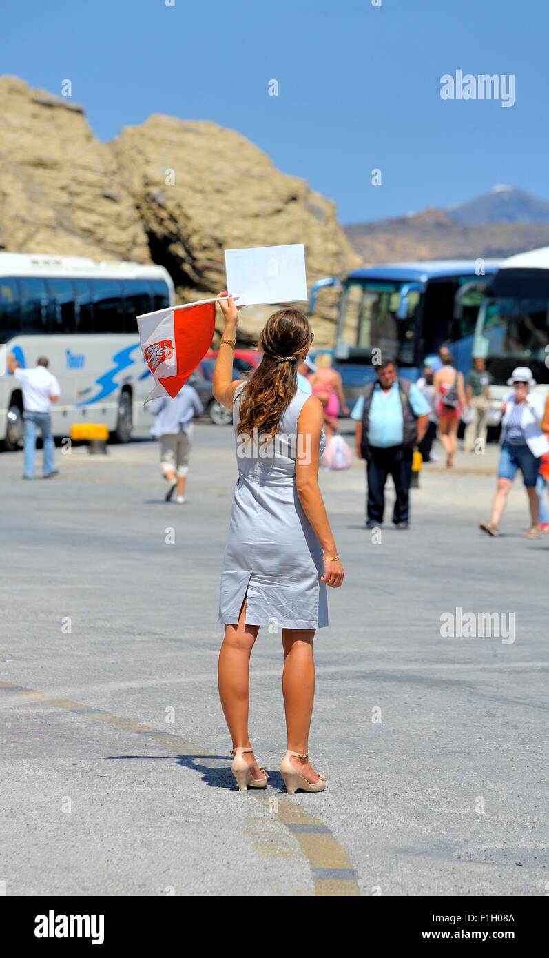 Day trip tour rep holding up tour trip numbers for passengers as they arrive in the port of Ormos Athinios Santorini Stock Photo