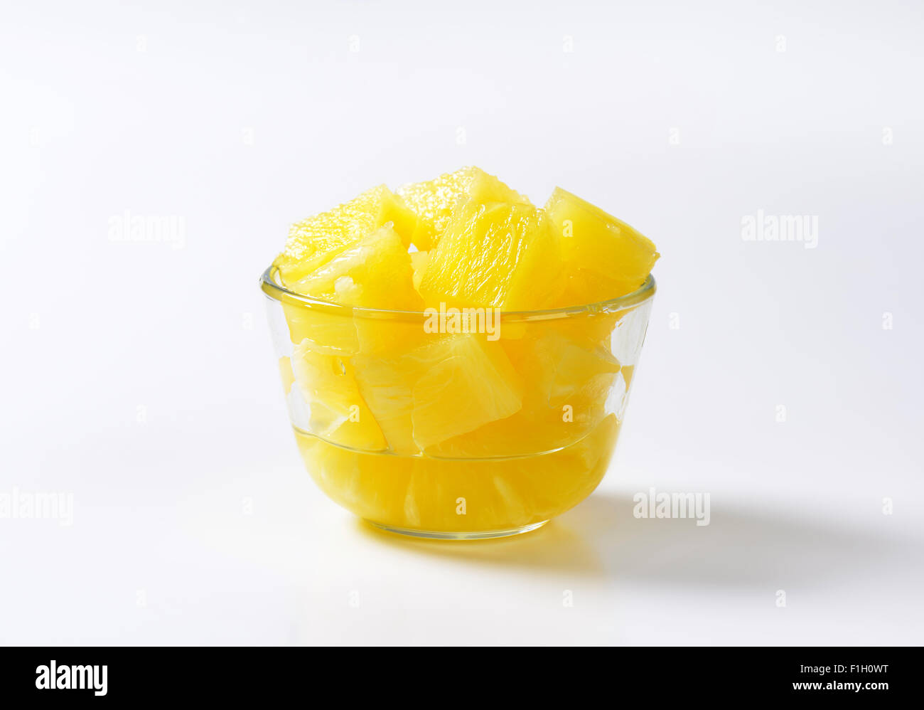 bowl of pineapple pieces on white background Stock Photo Alamy