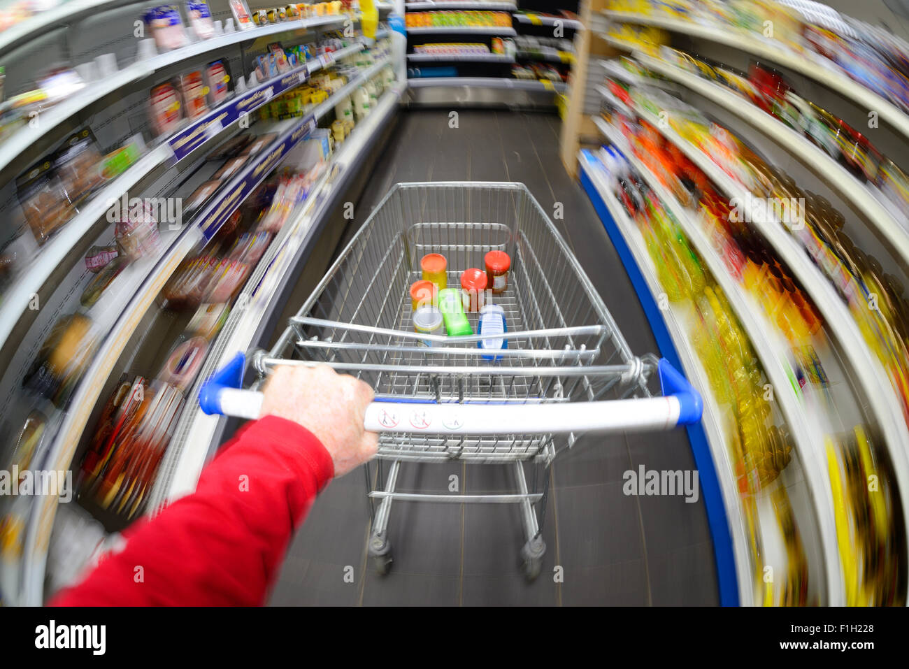 customer pushing shopping trolley at speed in supermarket Stock Photo