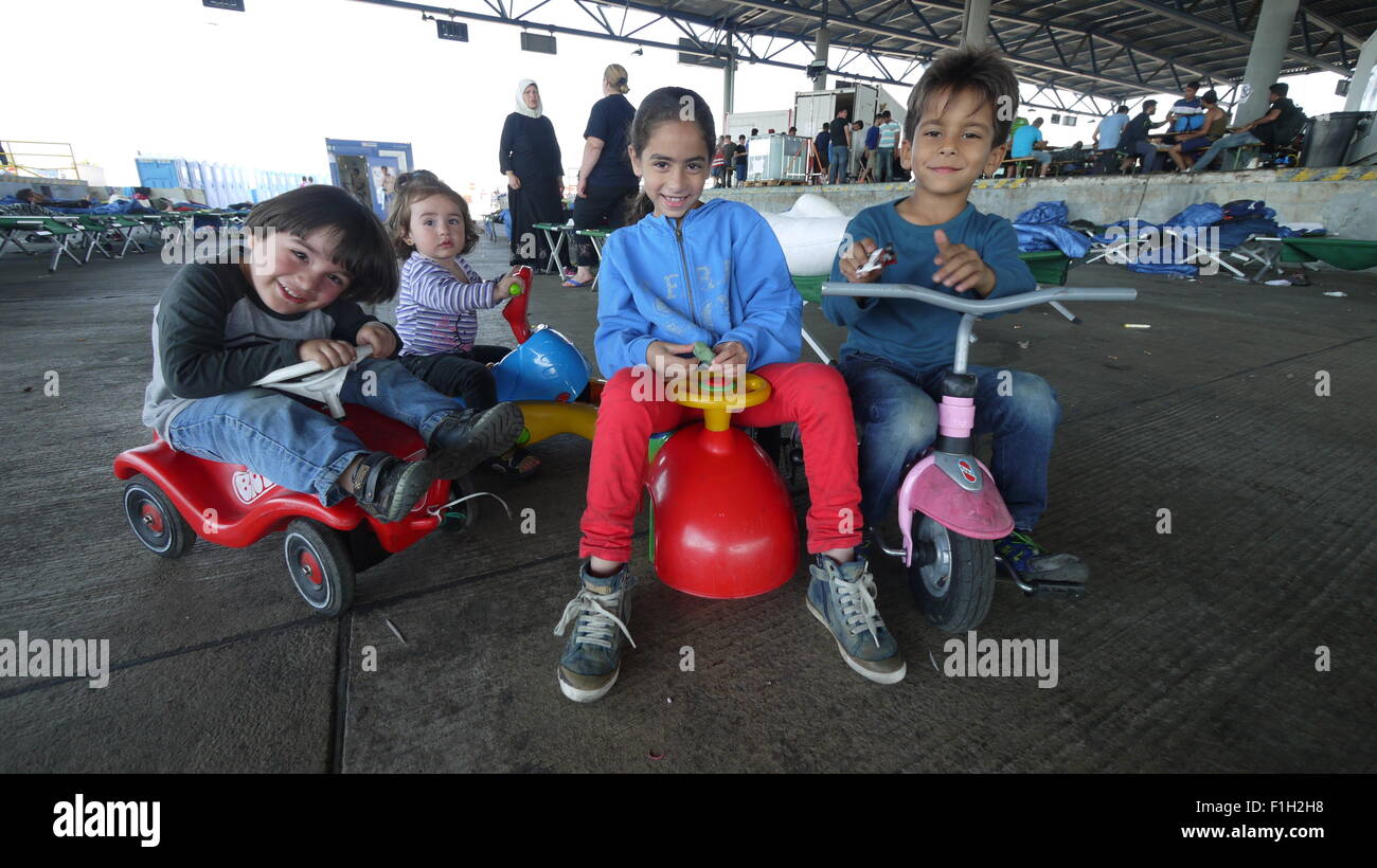 Four children play at a make-shift refugee processing centre near the Austro-Hungarian in Nickelsdorf, Austria, 1 September 2015. Photo: Matthias Roeder/dpa Stock Photo