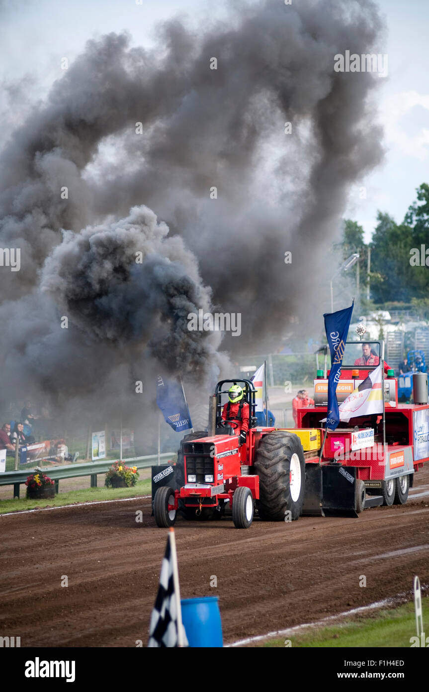 tractor puller competing in a tractor pull producing a huge cloud of thick black diesel smoke Stock Photo