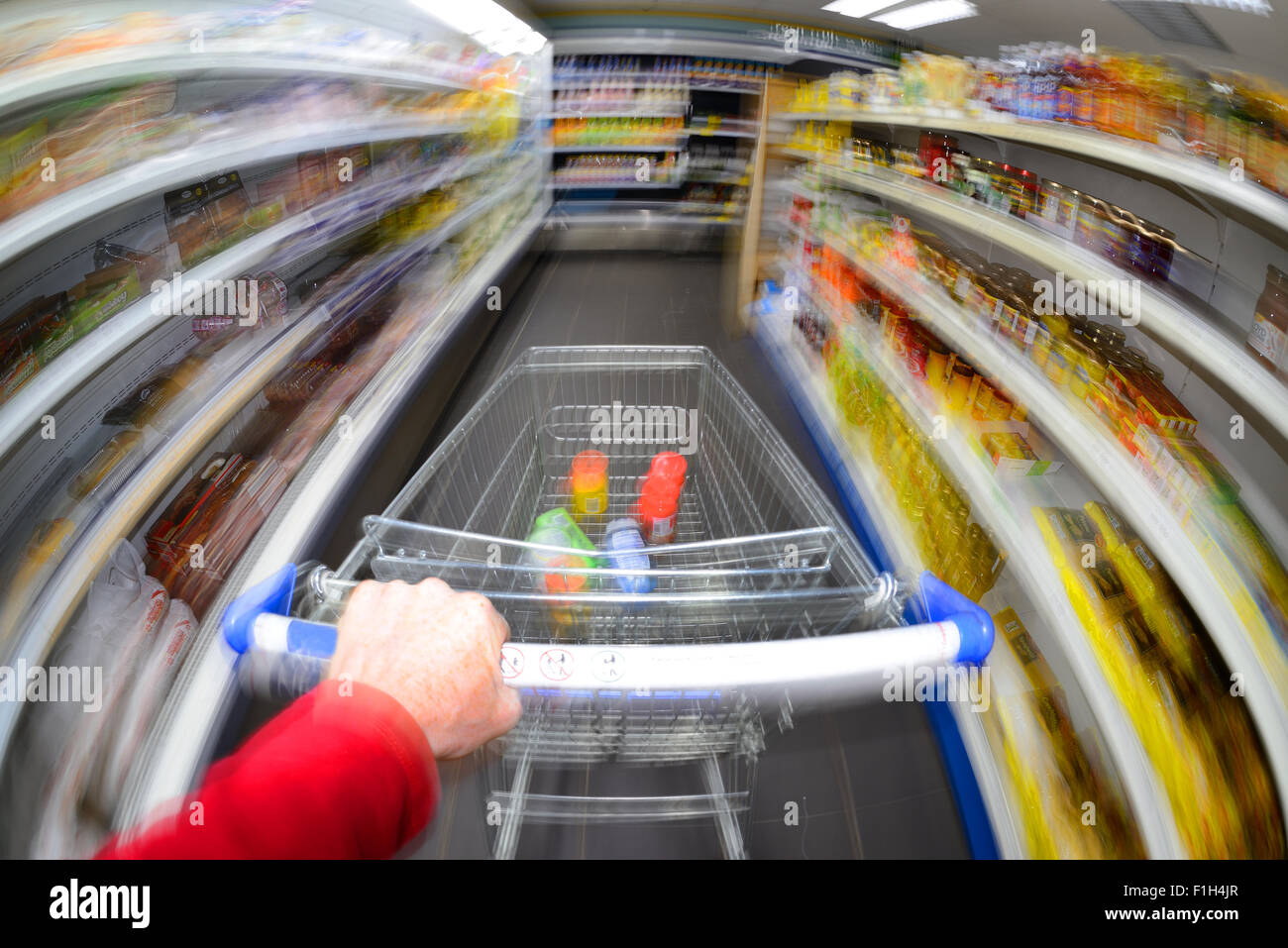 customer pushing shopping trolley at speed in supermarket Stock Photo