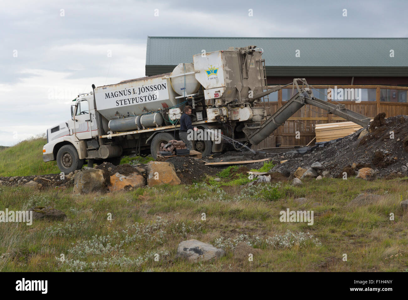 A man washing down equipment after a concrete pour for a new extension