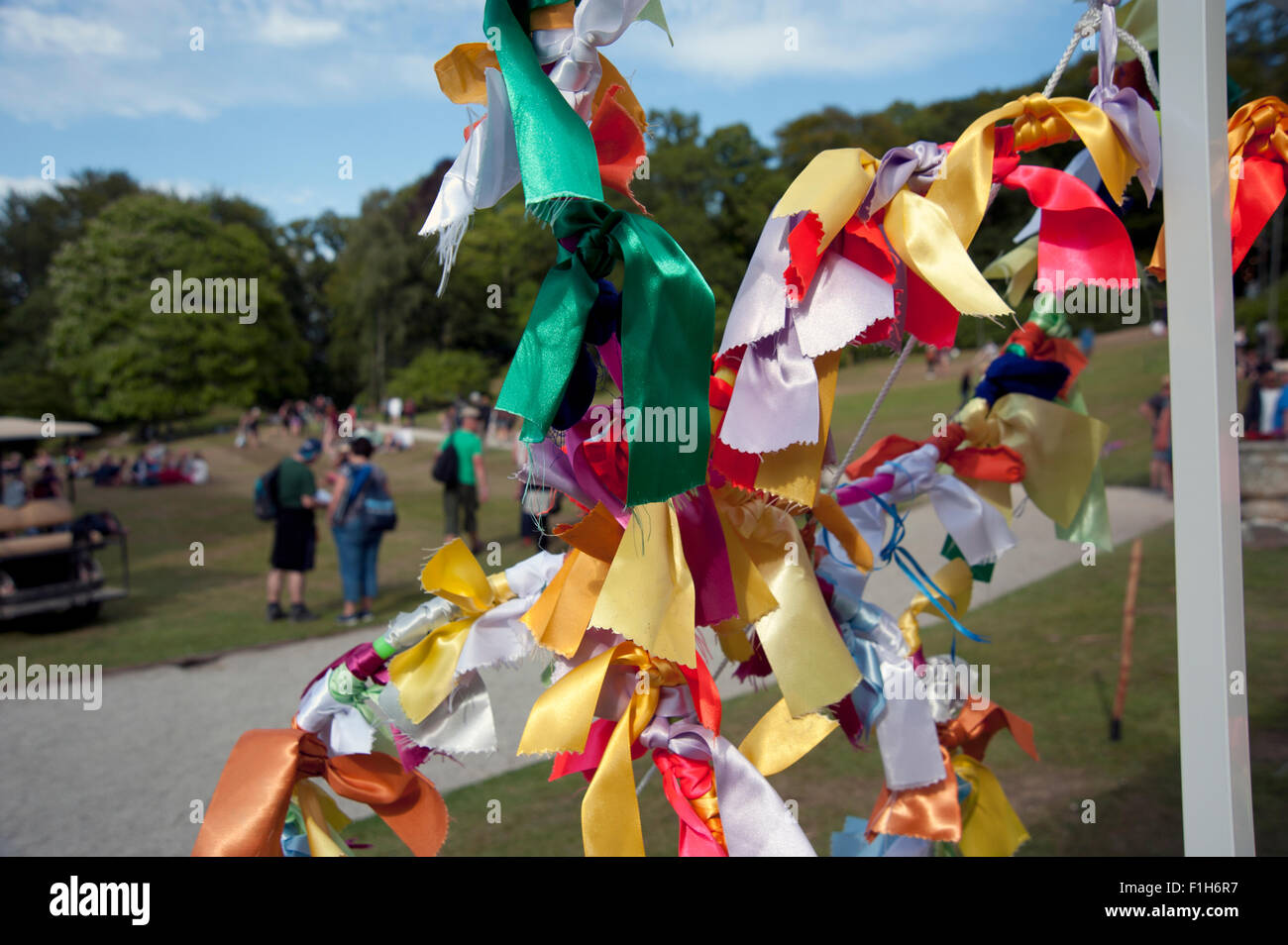 Multicoloured ribbon bunting tied to a stall guy rope with a crowd in ...