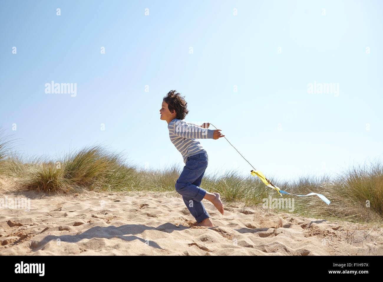 Young boy flying kite on beach Stock Photo