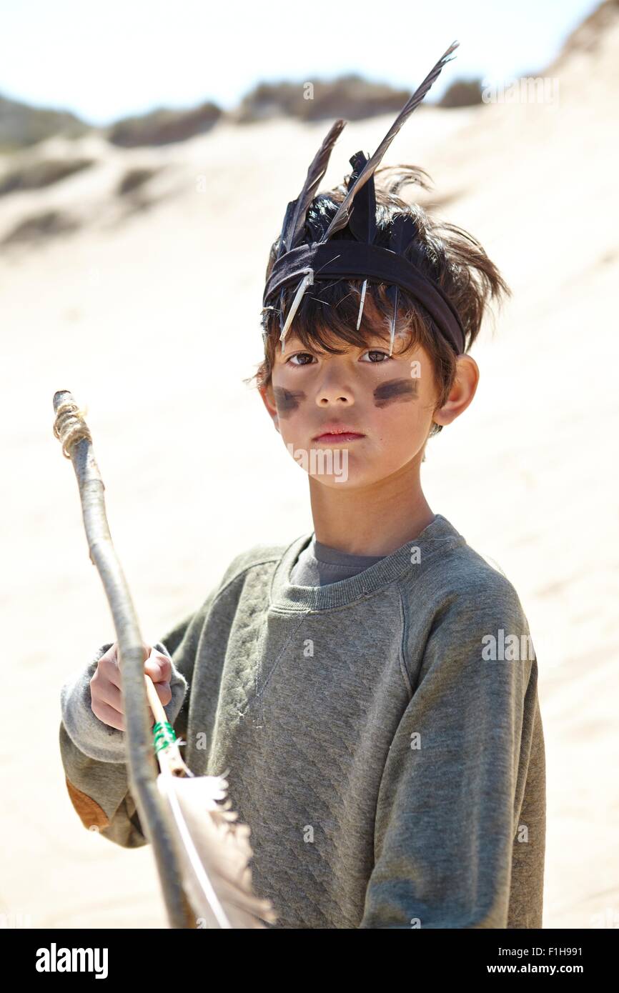 Young boy wearing fancy dress, holding home-made bow and arrow Stock Photo