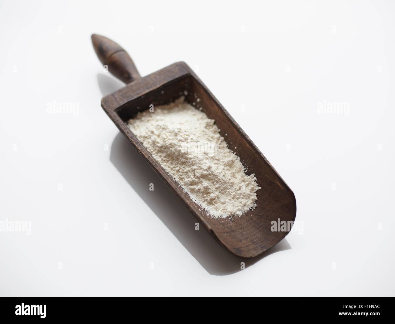 Flour in wooden scoop Stock Photo