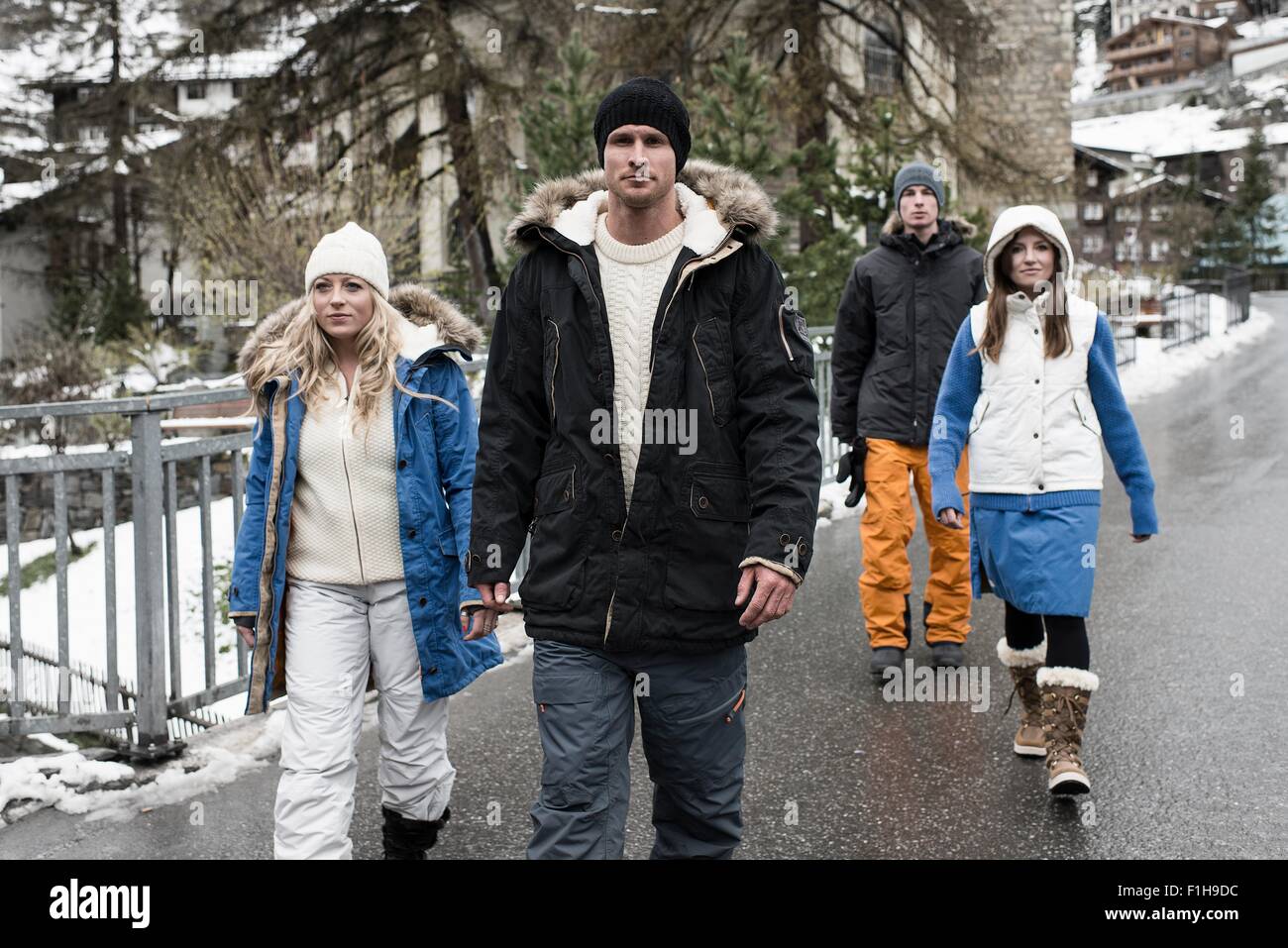 Four friends wearing winter clothes walking Stock Photo