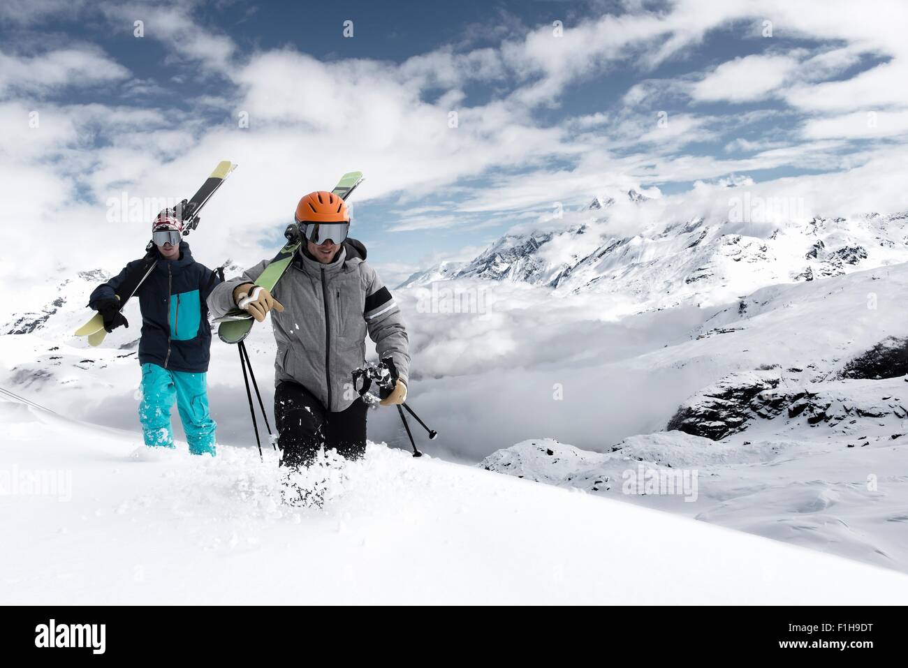 Men carrying skis in snow, Zermatt, Valais, Switzerland Stock Photo