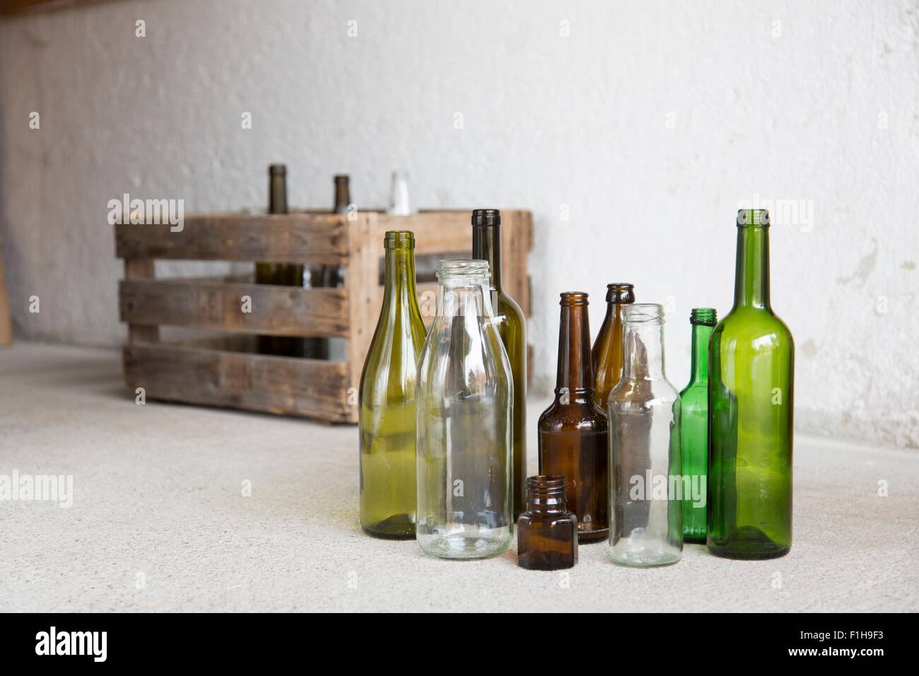 Variety of empty bottles and wooden crate in garage Stock Photo