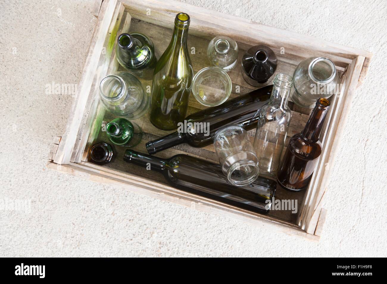 Wooden crate containing variety of empty bottles for recycling Stock Photo