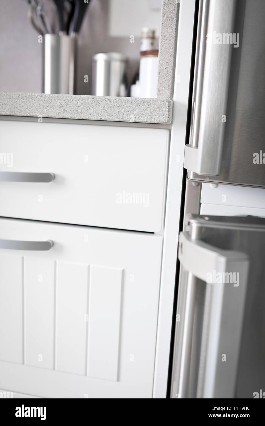 Detail of modern white kitchen. Drawers, fridge and kitchen tools Stock