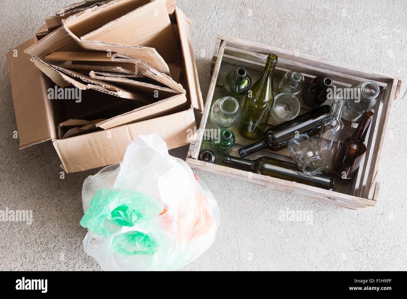 Wooden crate of empty bottles and cardboard box for recycling Stock Photo