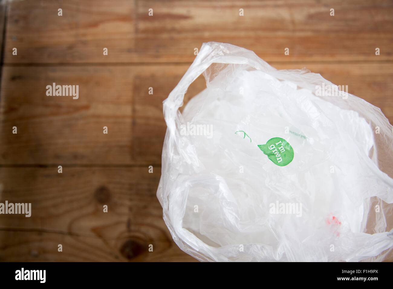 Recyclable plastic shopping bags on wooden floor Stock Photo
