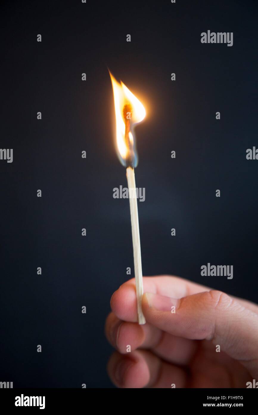 Person holding burning match Stock Photo