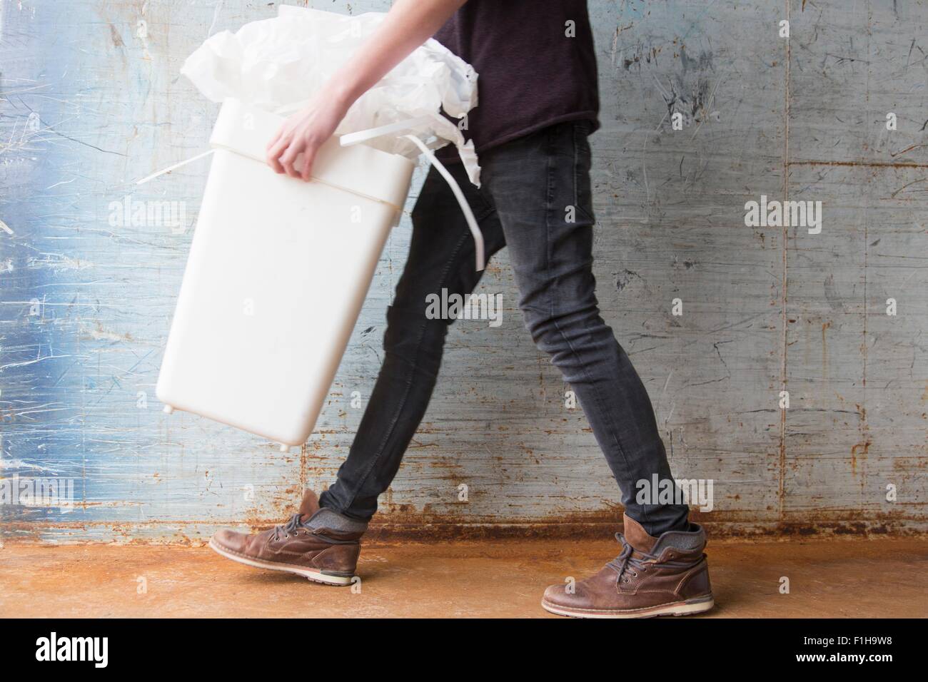 Teenage boy carrying bin with recyclable paper waste Stock Photo