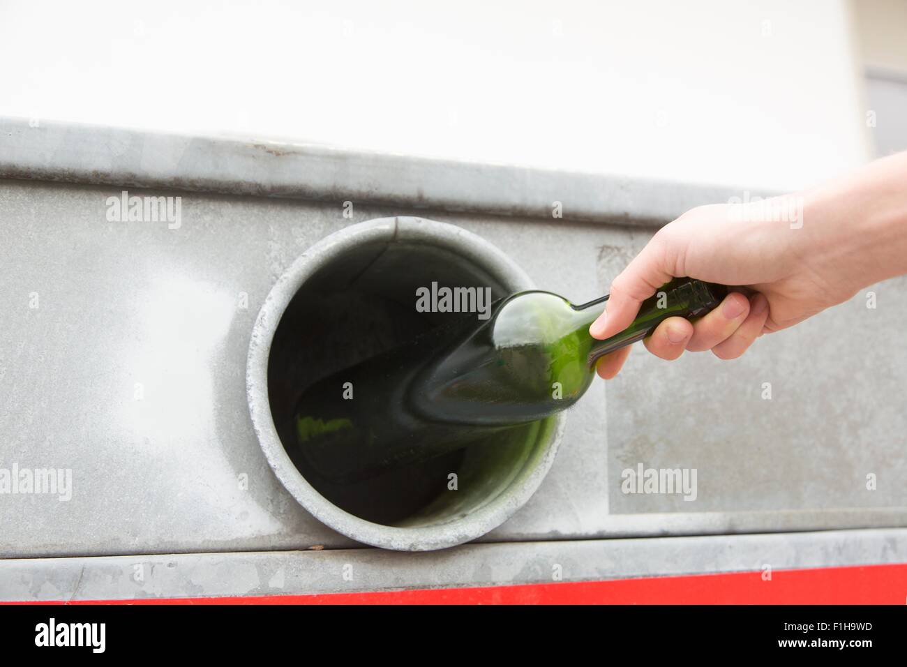 Person recycling wine bottle in bottle bank Stock Photo Alamy