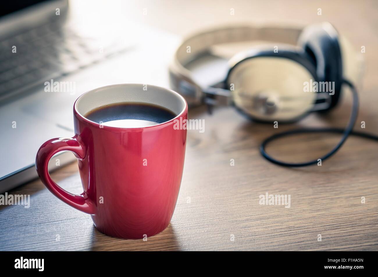 Still life of black coffee, headphones and laptop Stock Photo