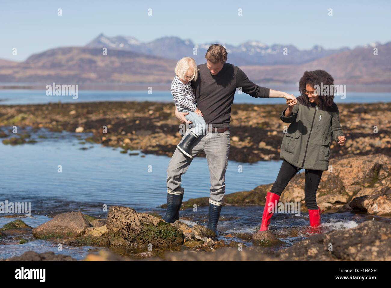Father holding son by Loch Eishort, Isle of Skye, Hebrides, Scotland Stock Photo