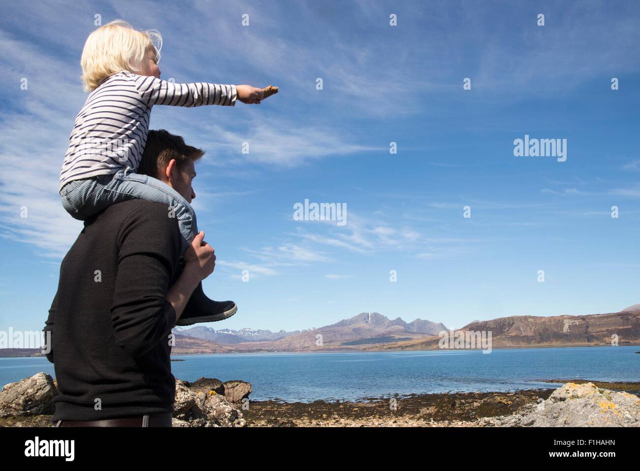 Father carrying son on shoulders, Loch Eishort, Isle of Skye, Hebrides, Scotland Stock Photo