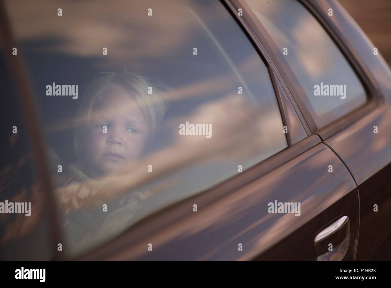 Boy looking through car window Stock Photo