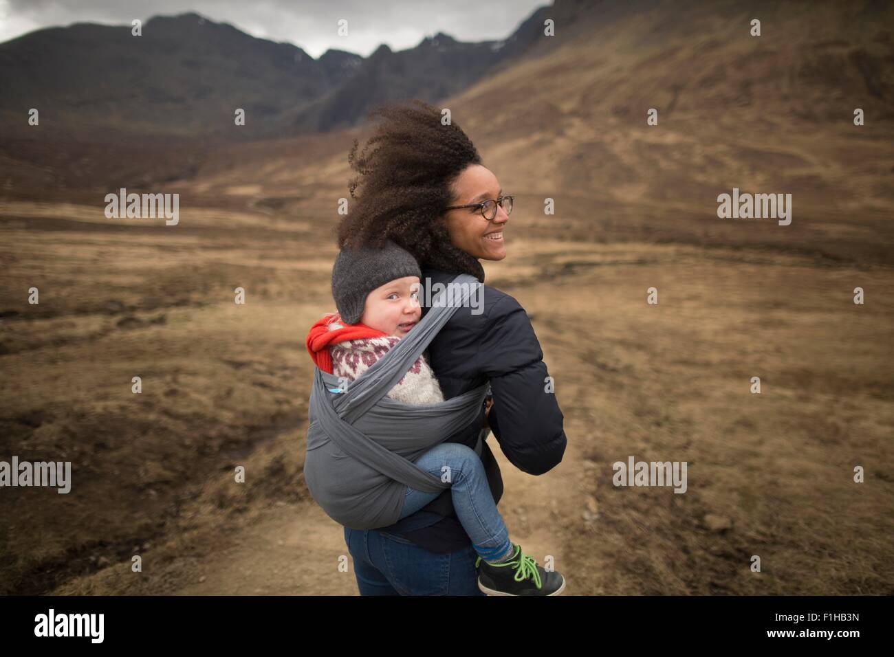 Mother carrying son in sling, Fairy Pools, near Glenbrittle, Isle of Skye, Hebrides, Scotland Stock Photo