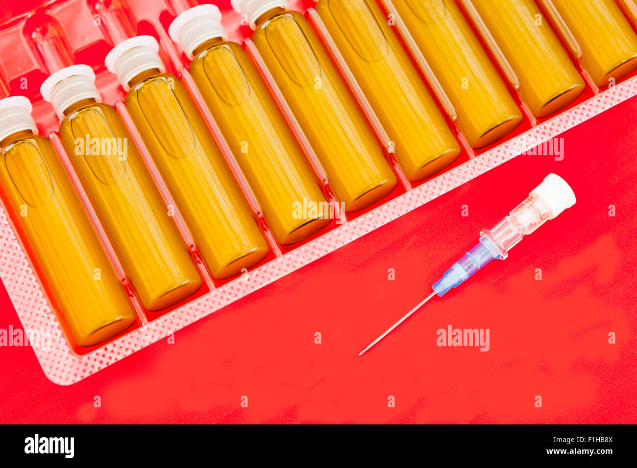 Medical blisters and blue needle isolated in red Stock Photo Alamy