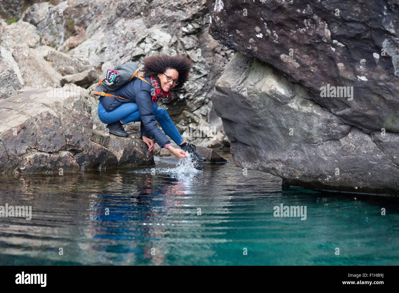 Mid adult woman crouching by pond Stock Photo