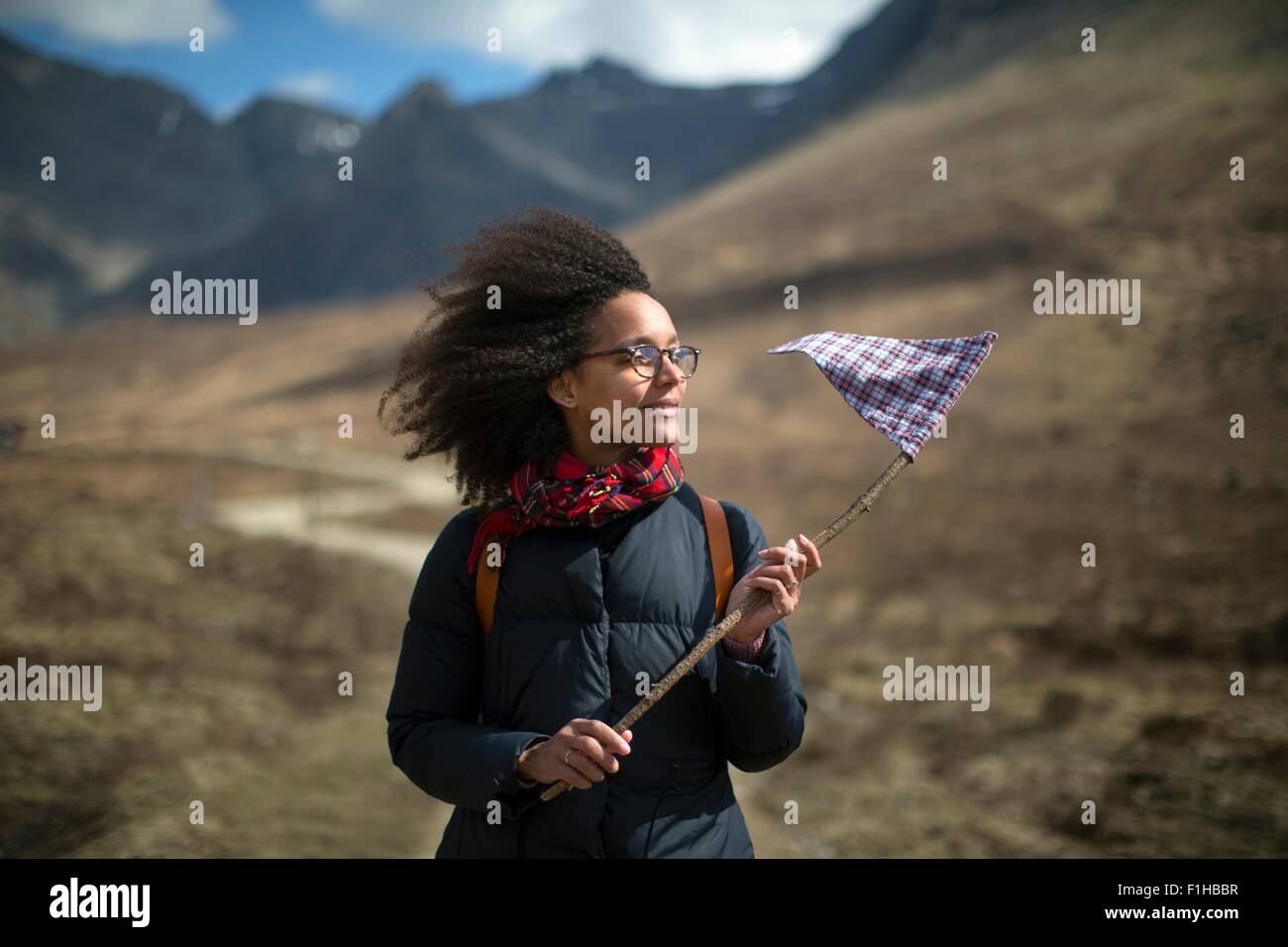 Mid adult woman holding flag, looking away Stock Photo