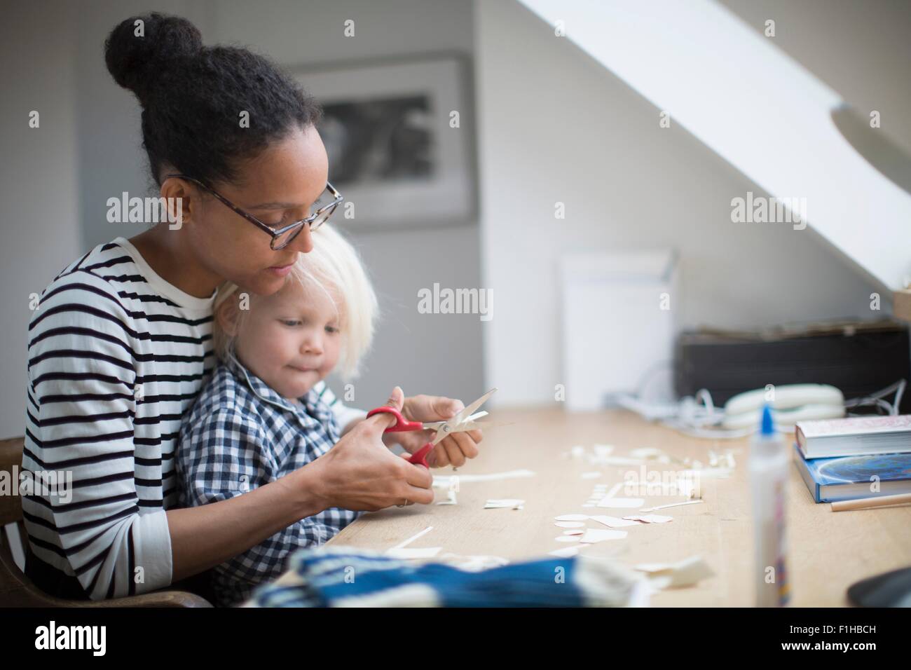 Mother showing son how to use scissors Stock Photo