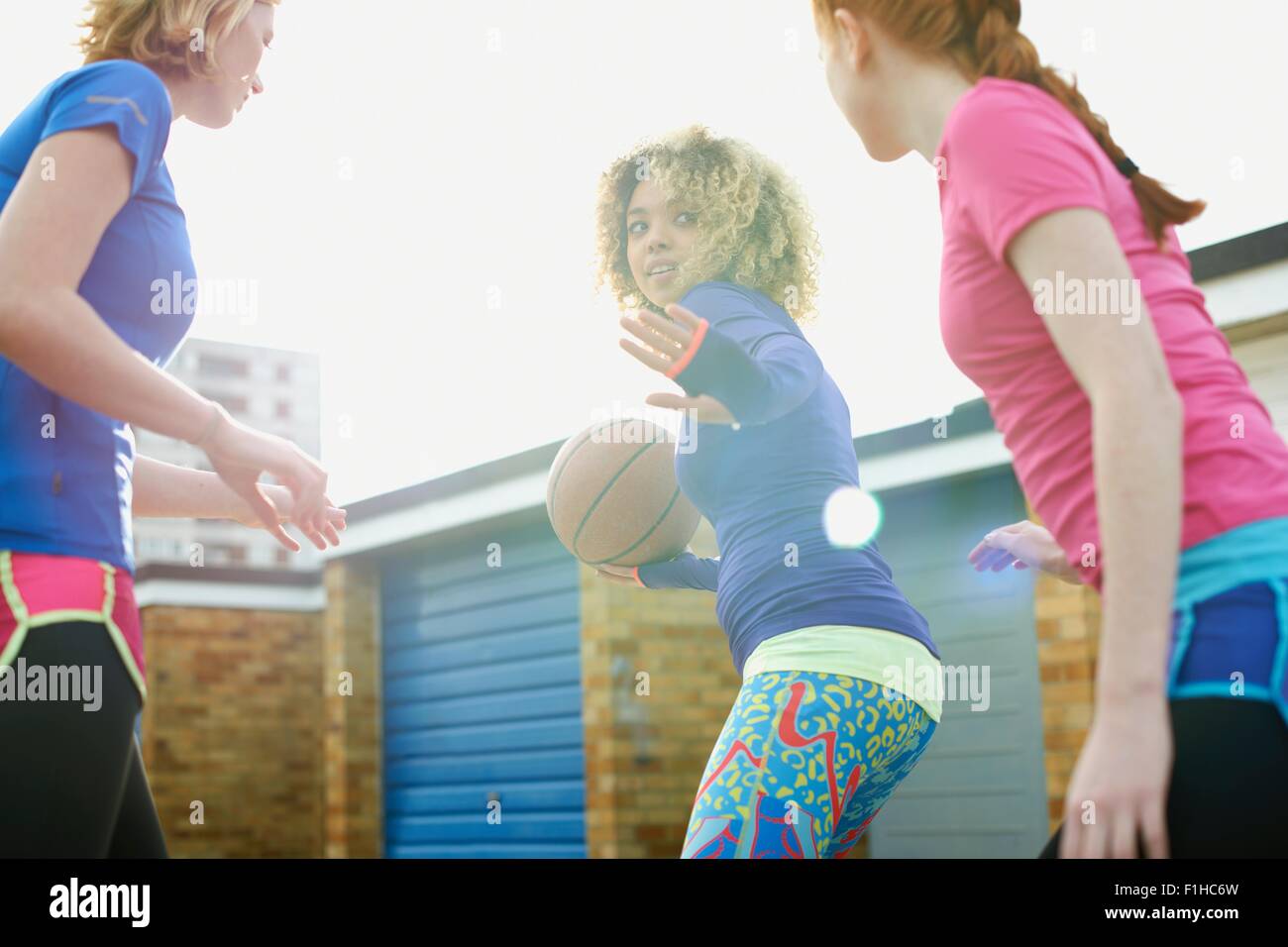 Portrait of three women exercising together playing basketball Stock Photo