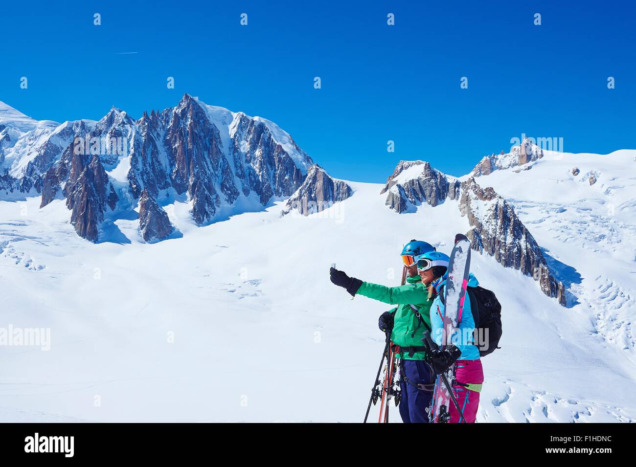 Mature male and female skiers taking smartphone selfie on Mont Blanc massif, Graian Alps, France Stock Photo