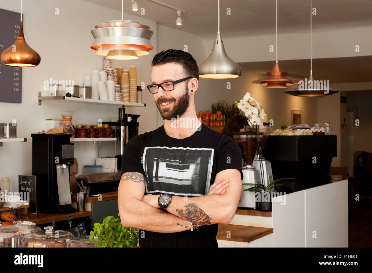 Portrait of cafe waiter with arms folded Stock Photo